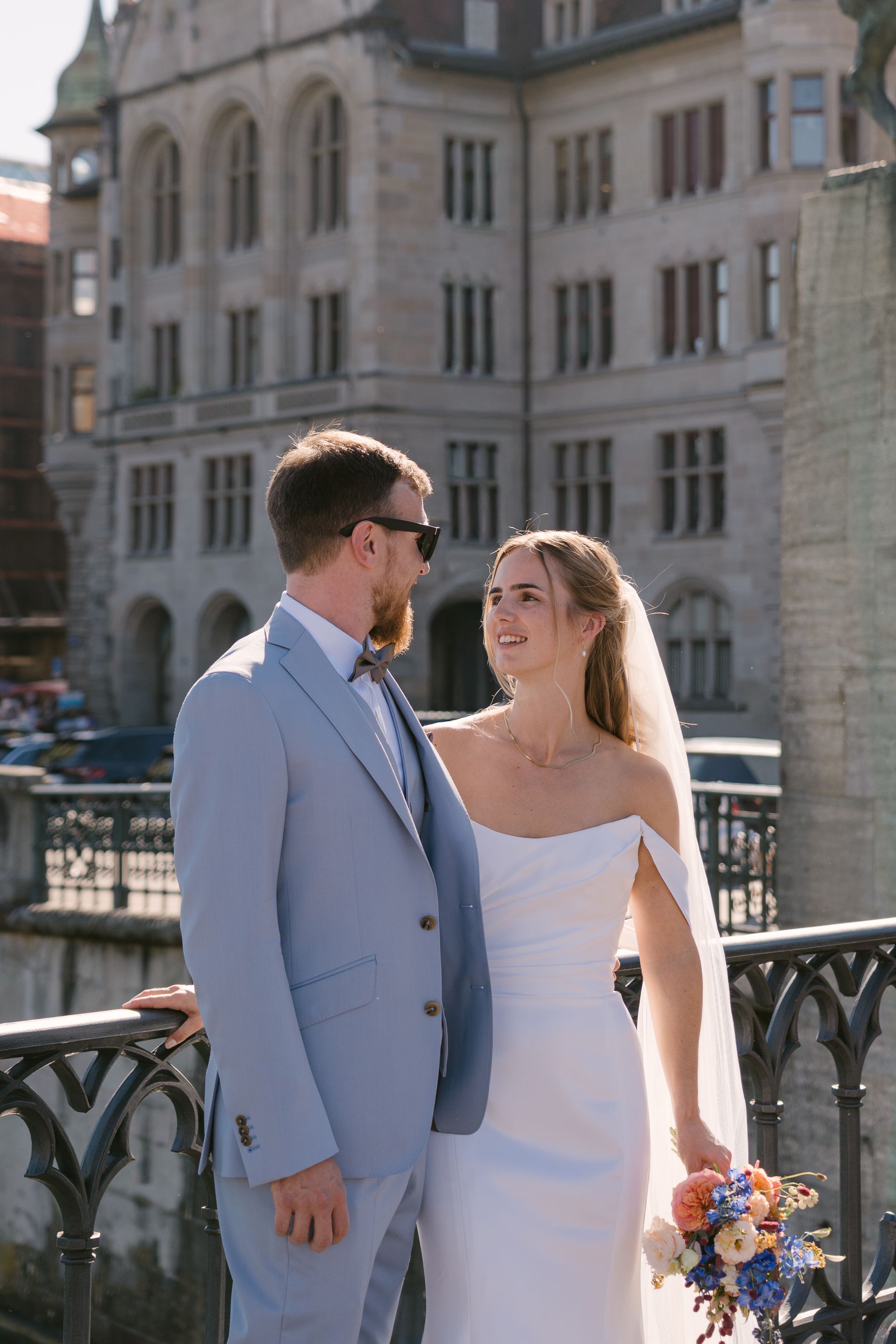 A bride and groom standing by the Stadthaus in Zürich