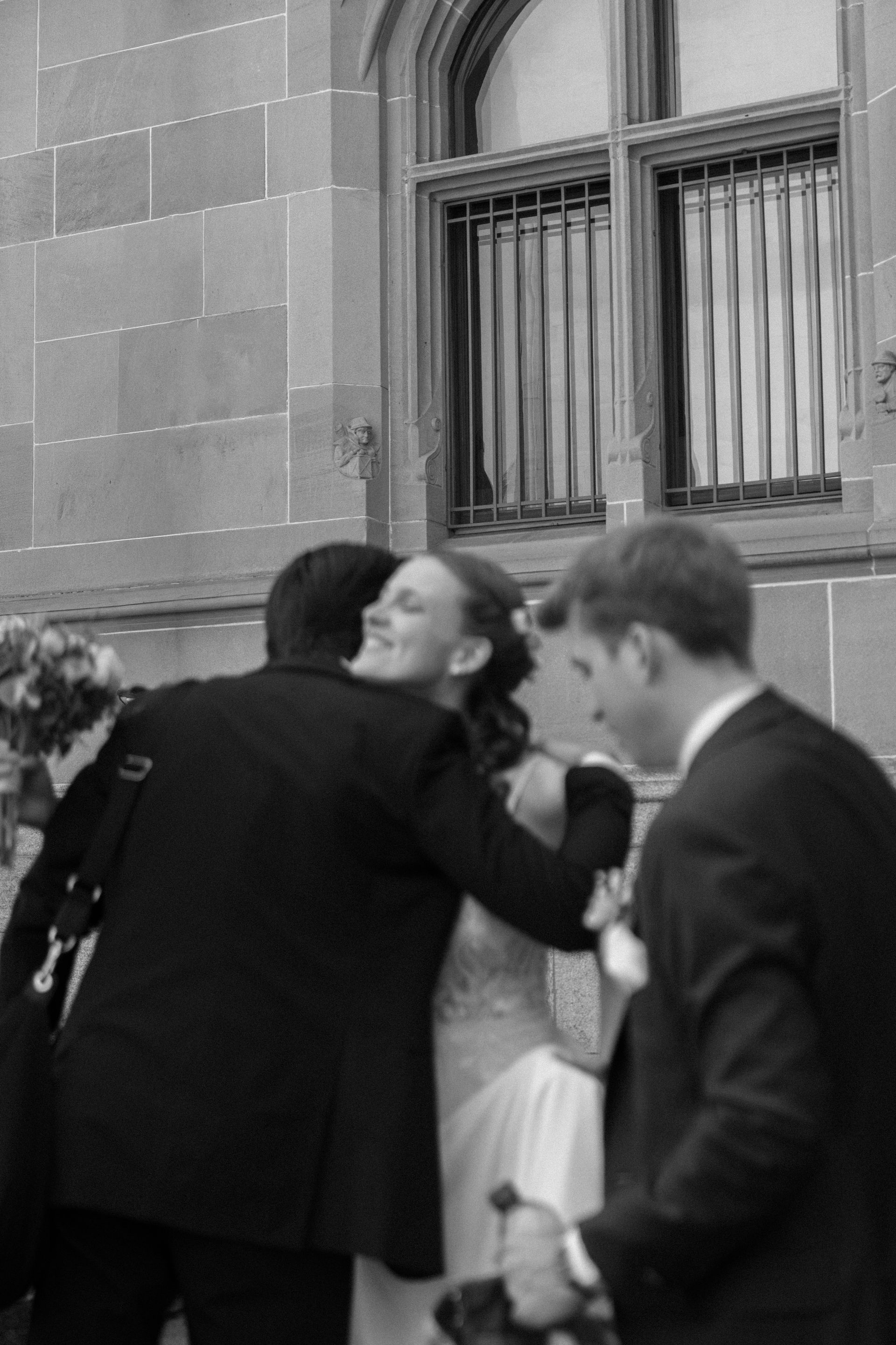 A bride hugging her guests after the ceremony, in black and white