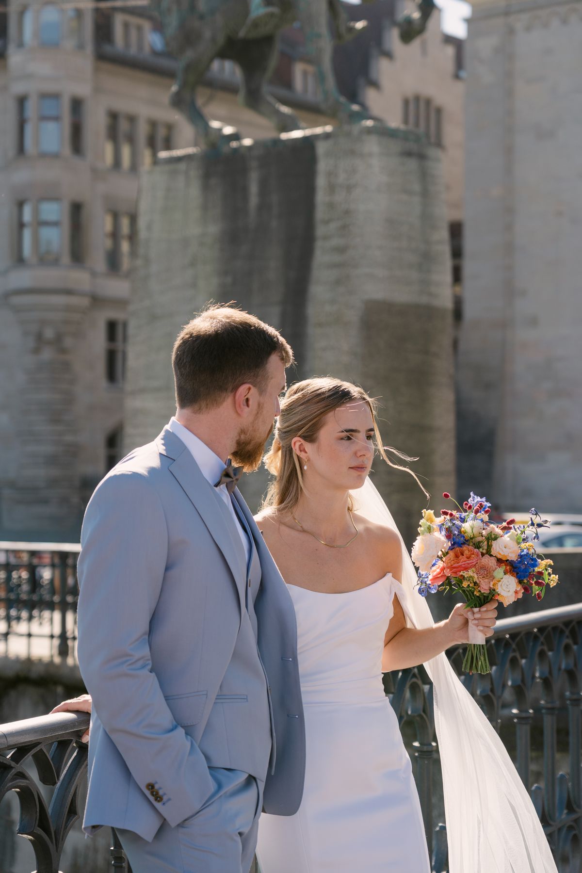 A bride and groom standing by the Stadthaus in Zürich
